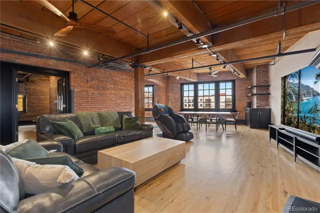 a living room with furniture a wooden floor and next to a window