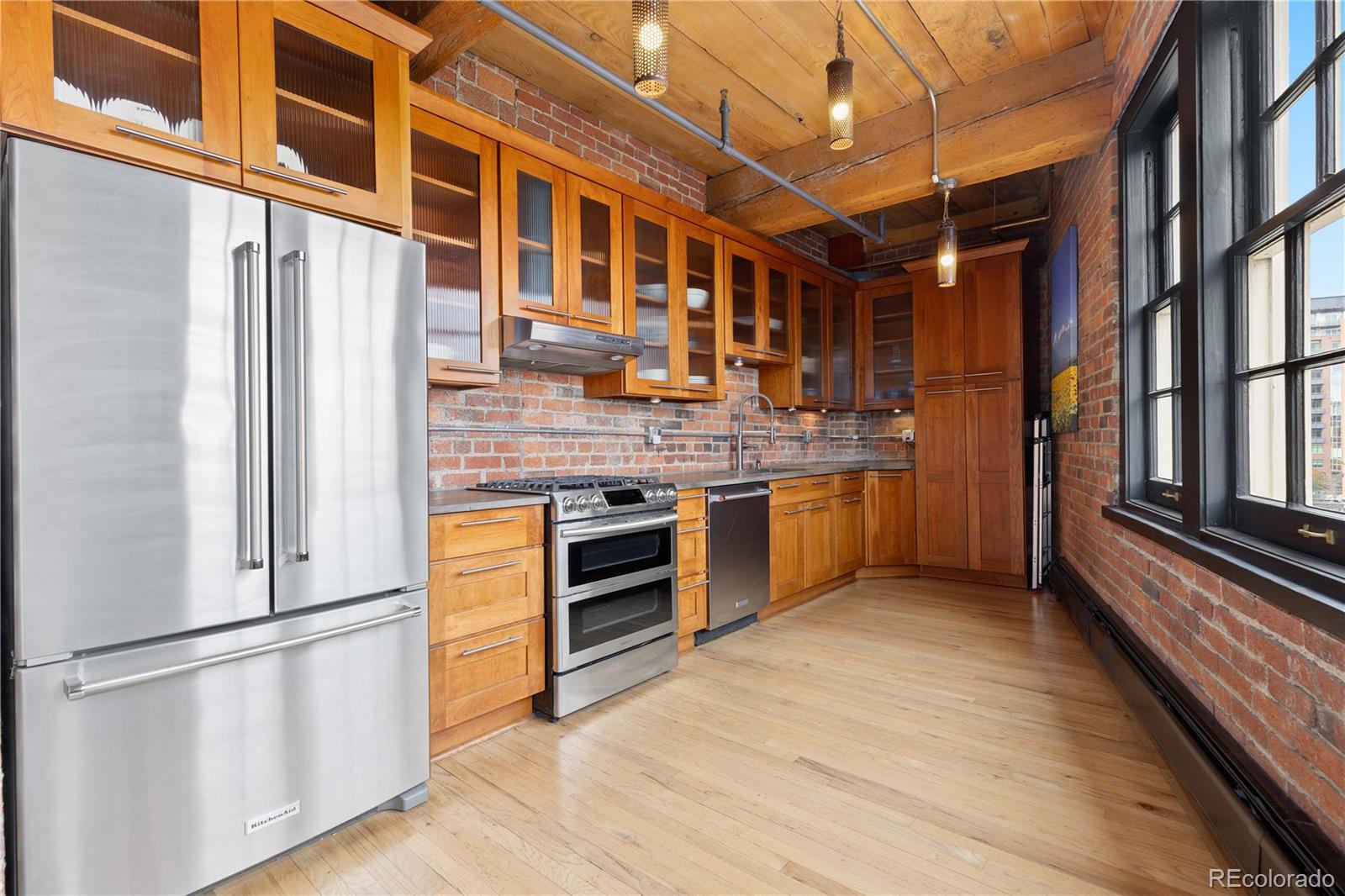 1616 14th Street, Unit 4A Denver, CO 80202 - Photo 17 of 43 a kitchen with stainless steel appliances granite countertop a stove and a refrigerator