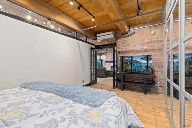 a bedroom with a bed a table and a potted plant