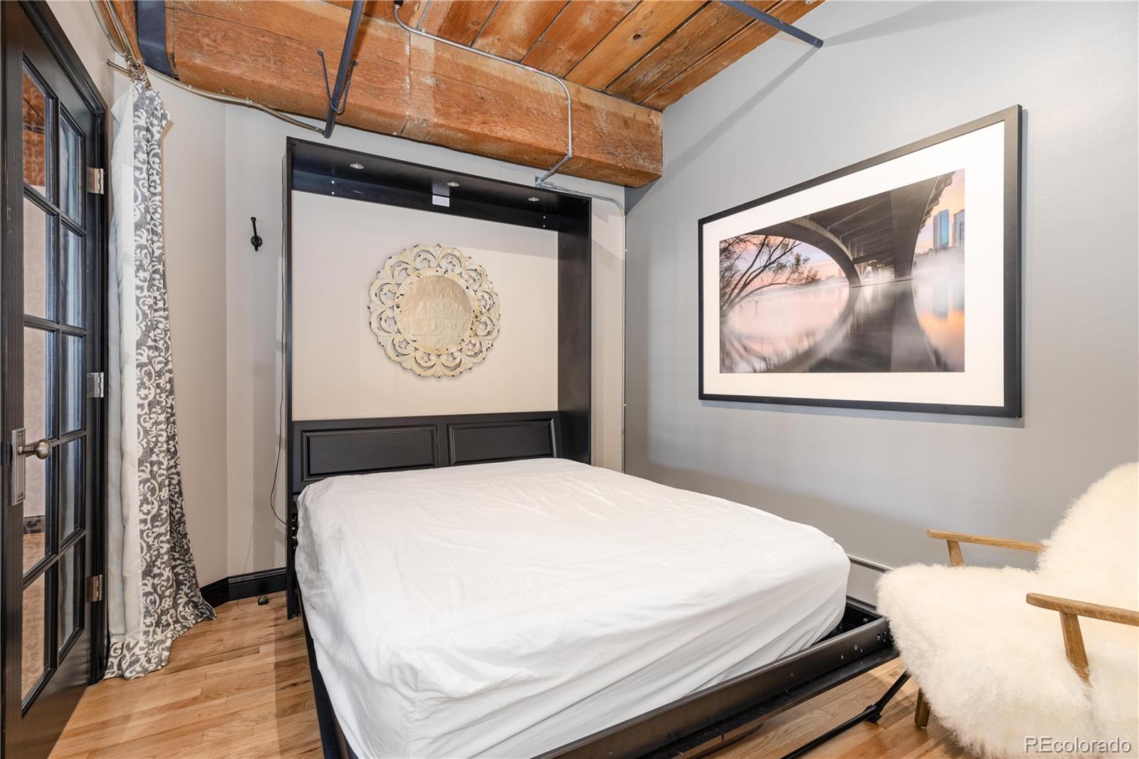 1616 14th Street, Unit 4A Denver, CO 80202 - Photo 25 of 43 a bedroom with a bed and a painting on the wall