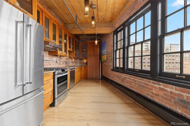 a view of a kitchen with stainless steel appliances granite countertop a refrigerator and a stove top oven