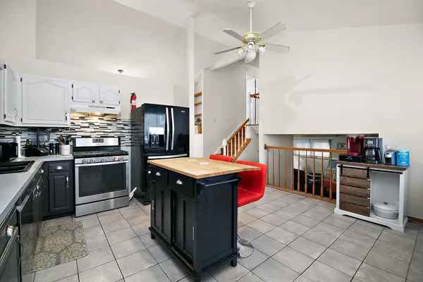 a kitchen with stainless steel appliances granite countertop a stove top oven a sink dishwasher and a refrigerator