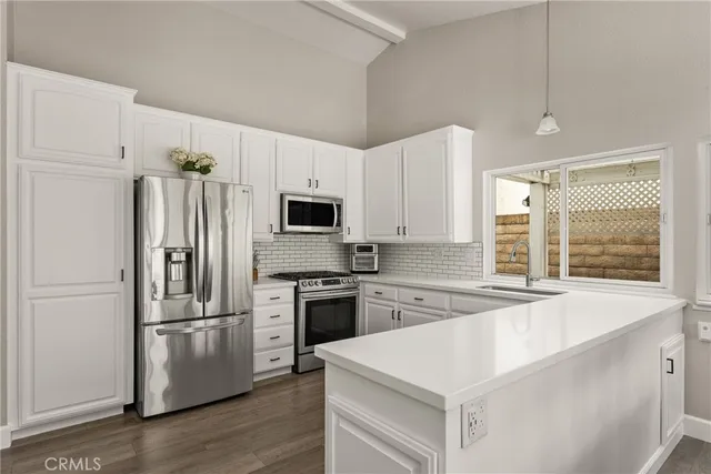 a kitchen with stainless steel appliances a refrigerator sink and microwave