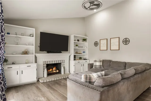a living room with furniture a fireplace and a flat screen tv