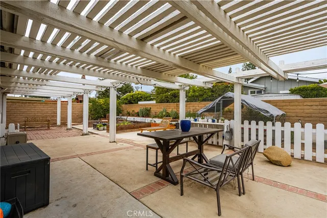 a view of a patio with a table and chairs and a barbeque