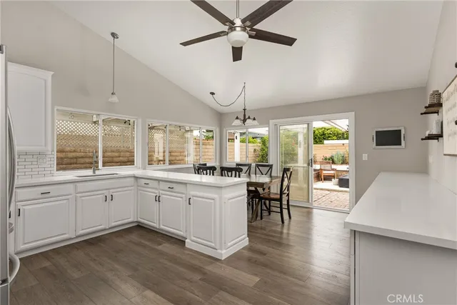a kitchen with a table chairs and white cabinets