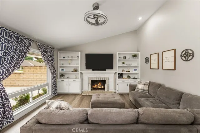 a living room with furniture a flat screen tv and a fireplace