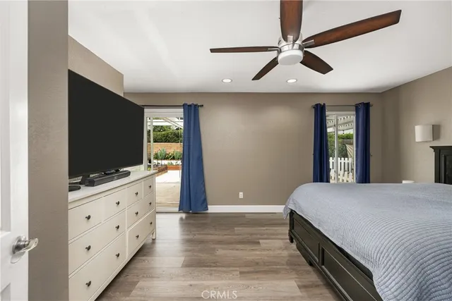 a bedroom with a bed and a flat screen tv on dresser