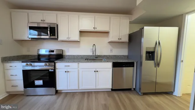 a kitchen with stainless steel appliances granite countertop a stove a refrigerator and a microwave