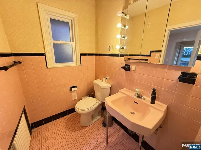 a bathroom with a sink mirror and toilet