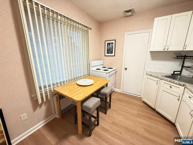 a kitchen with a table chairs and a refrigerator
