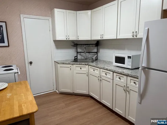 a kitchen with stainless steel appliances granite countertop a sink a stove and a refrigerator
