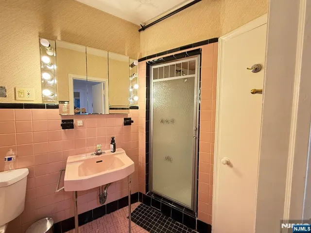 a bathroom with a sink a toilet and shower