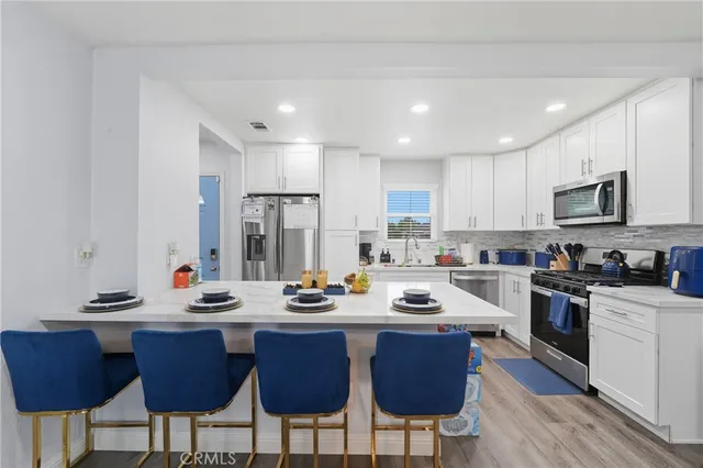 a kitchen with a refrigerator and a stove top oven