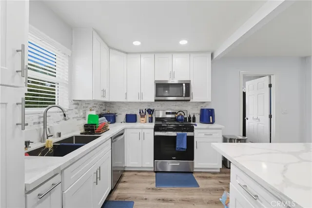 a kitchen with stainless steel appliances a sink a stove top oven a sink and cabinets