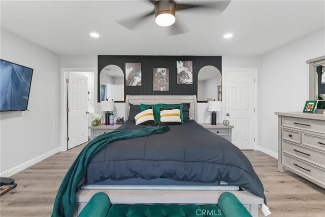 a bedroom with a bed and dresser with mirror