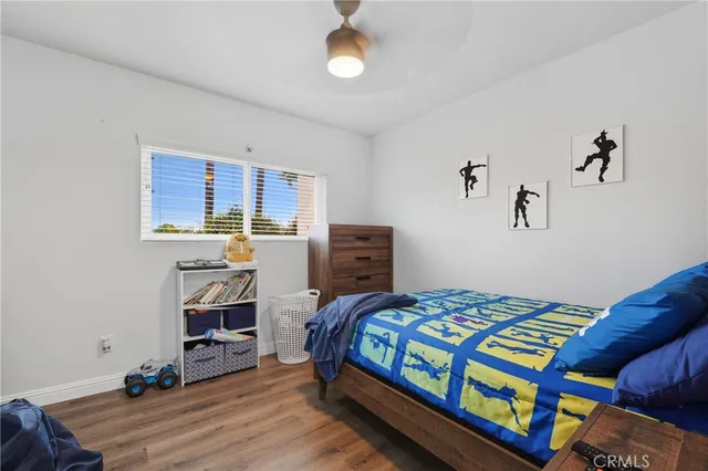 a bedroom with a bed and a wooden floor