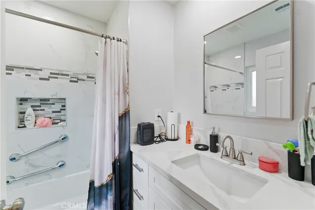 a bathroom with a sink vanity tub and shower