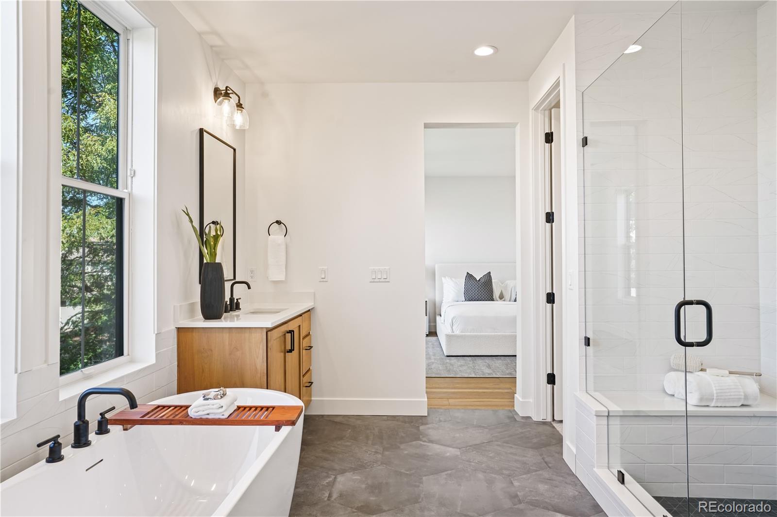 1067 South Cook Street Denver, CO 80209 - Photo 26 of 35 a bathroom with a tub sink and mirror