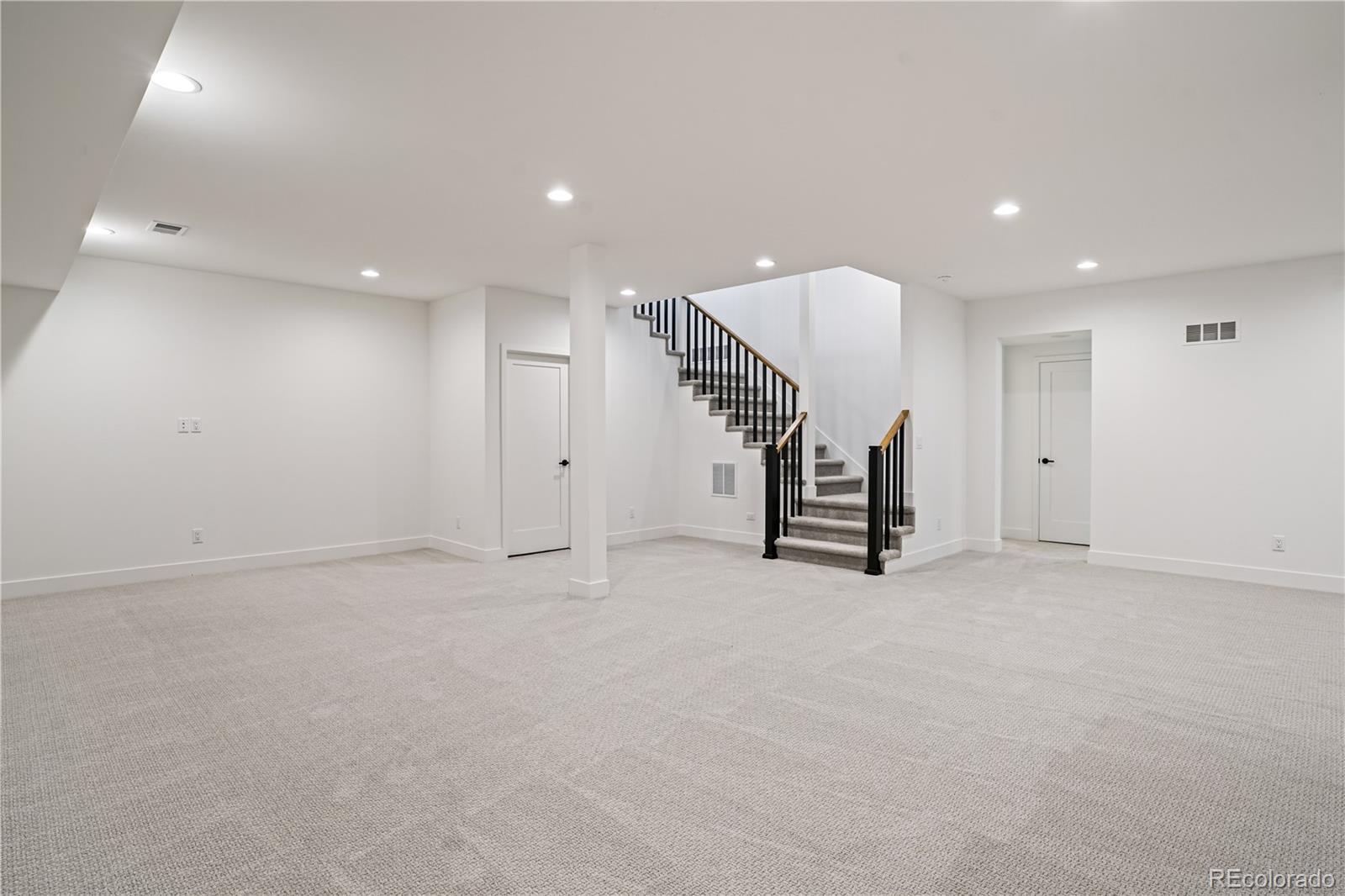 1067 South Cook Street Denver, CO 80209 - Photo 29 of 35 an empty room with staircase and white walls