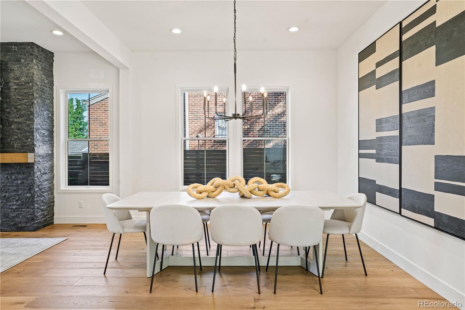 1067 South Cook Street Denver, CO 80209 - Photo 4 of 35 a dining room with furniture a chandelier and wooden floor