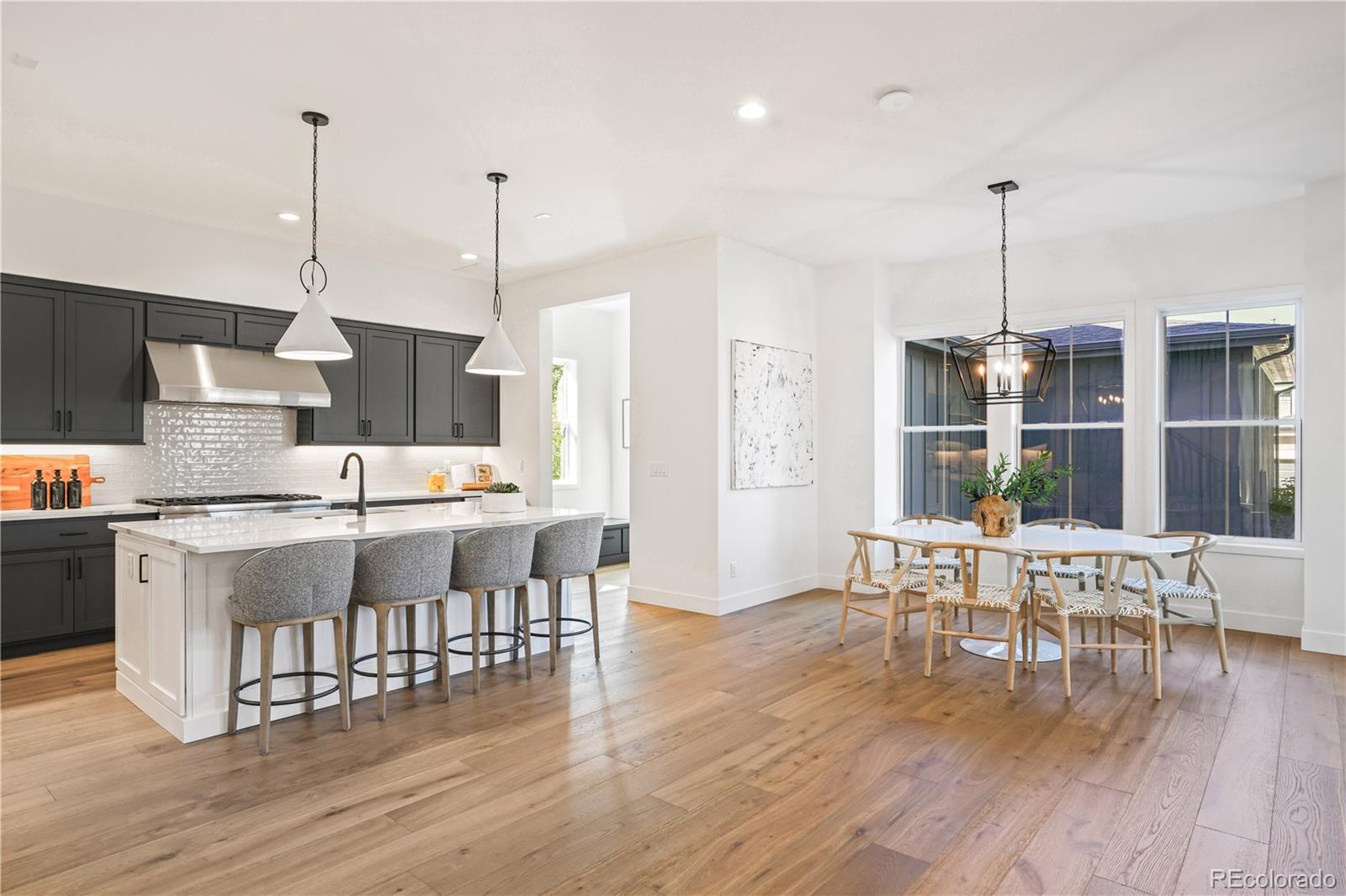 1067 South Cook Street Denver, CO 80209 - Photo 10 of 35 a open kitchen with stainless steel appliances granite countertop a stove top oven a dining table and chairs with wooden floor