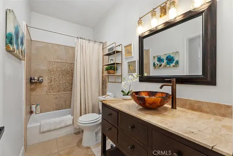 a bathroom with a granite countertop sink a toilet and shower