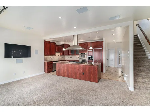 a kitchen with stainless steel appliances kitchen island granite countertop a stove and a sink