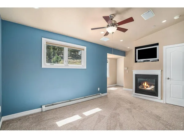 a view of an empty room with a ceiling fan and a window