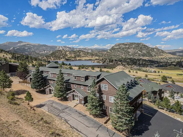 an aerial view of a house with a mountain