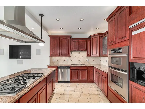 a kitchen with stainless steel appliances granite countertop a stove top oven a sink dishwasher and a microwave oven on the blue kitchen countertops