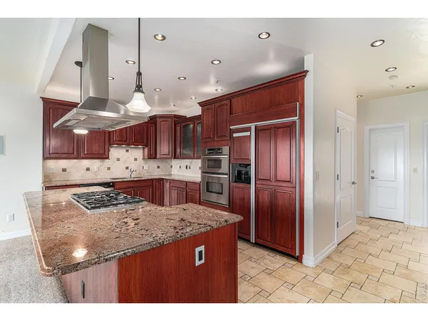 a kitchen with stainless steel appliances granite countertop a sink and a refrigerator