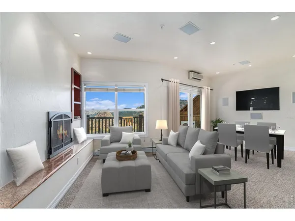 a living room with furniture a flat screen tv and a chandelier