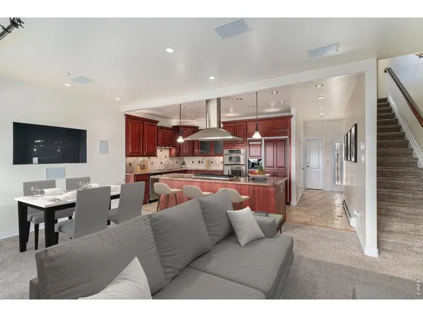 a living room with stainless steel appliances kitchen island granite countertop furniture and a view of kitchen
