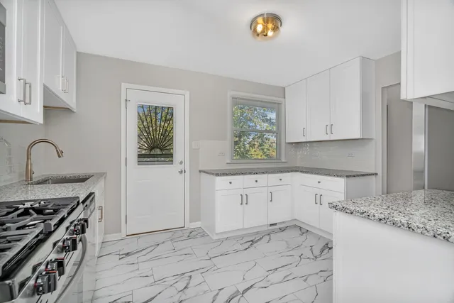 a kitchen with granite countertop a stove a sink and a counter space