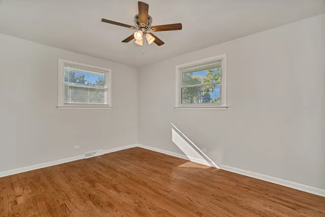 a view of room with wooden floor and ceiling fan