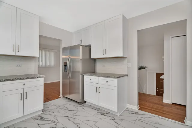 a kitchen with white cabinets and white appliances