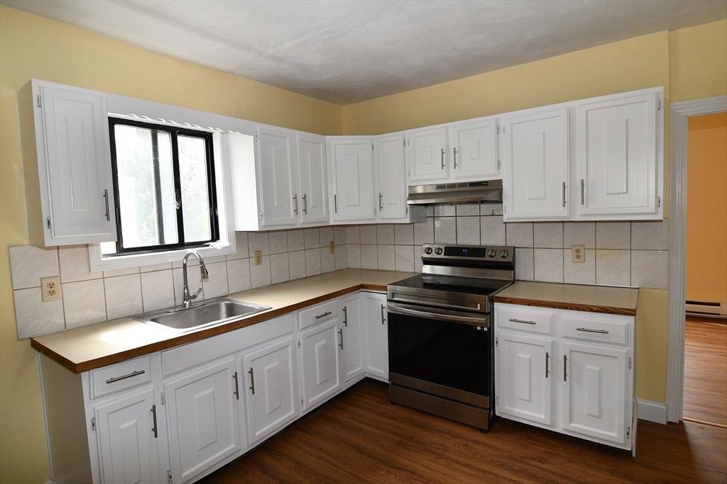112 Johnson Street Lynn, MA 01902 - Photo 11 of 28 a kitchen with stainless steel appliances granite countertop a sink stove and cabinets