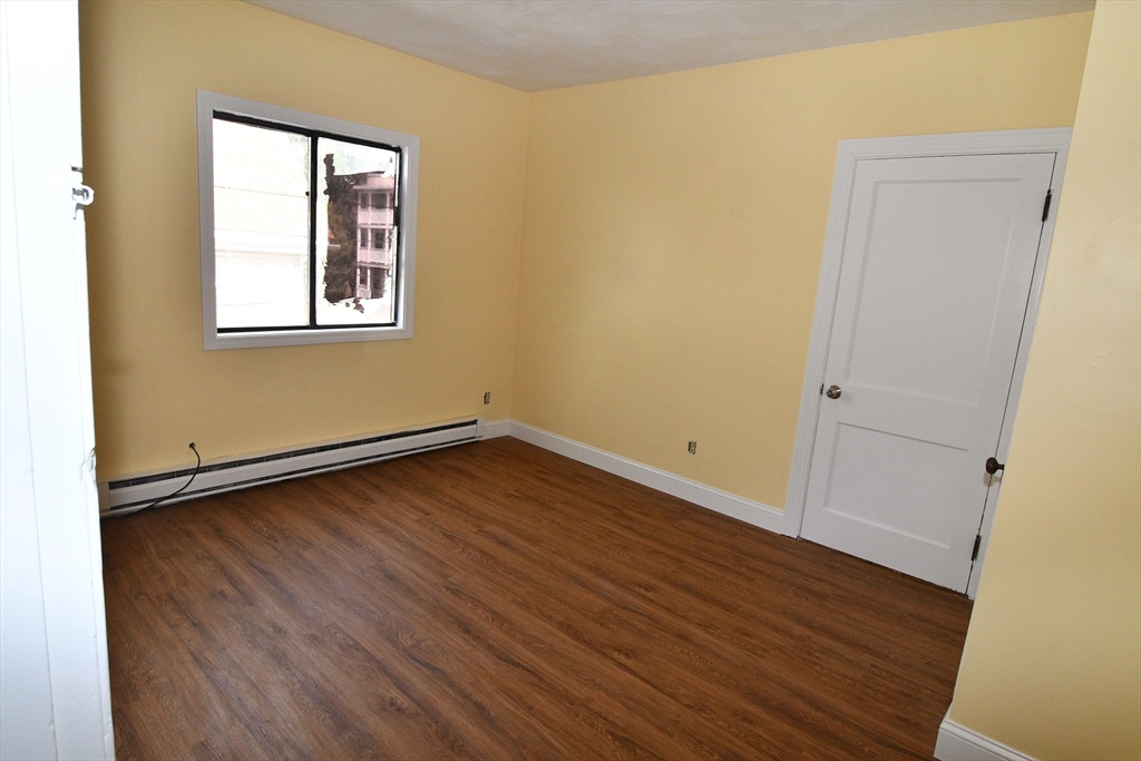 112 Johnson Street Lynn, MA 01902 - Photo 14 of 28 an empty room with wooden floor and windows