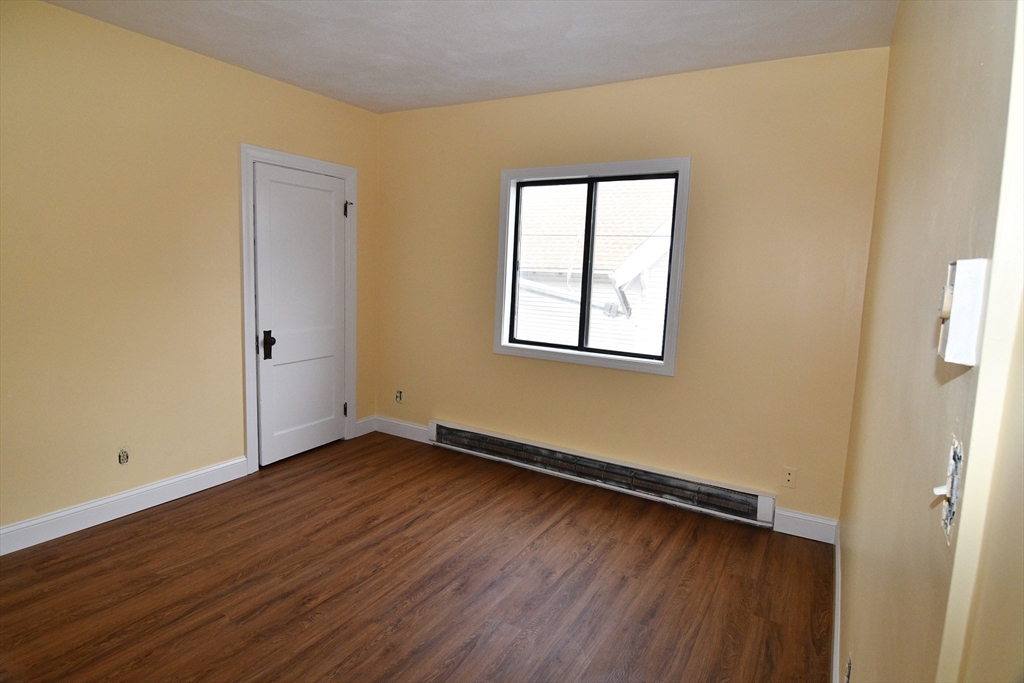 112 Johnson Street Lynn, MA 01902 - Photo 16 of 28 an empty room with wooden floor and windows