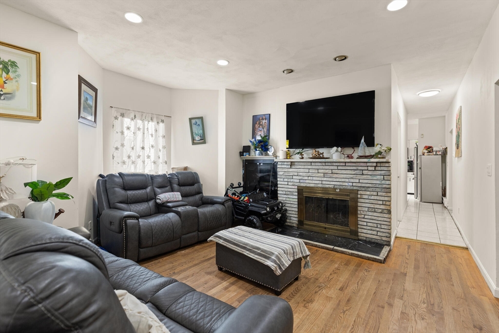 112 Johnson Street Lynn, MA 01902 - Photo 17 of 28 a living room with furniture a flat screen tv and a fireplace