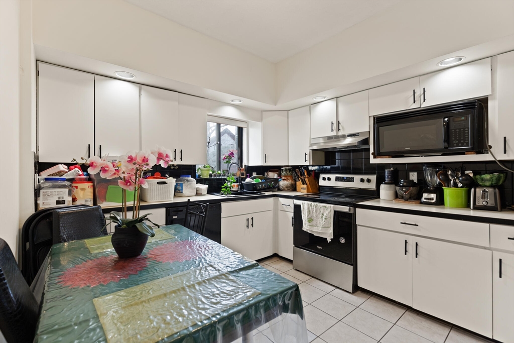 112 Johnson Street Lynn, MA 01902 - Photo 21 of 28 a kitchen with microwave a stove and cabinets