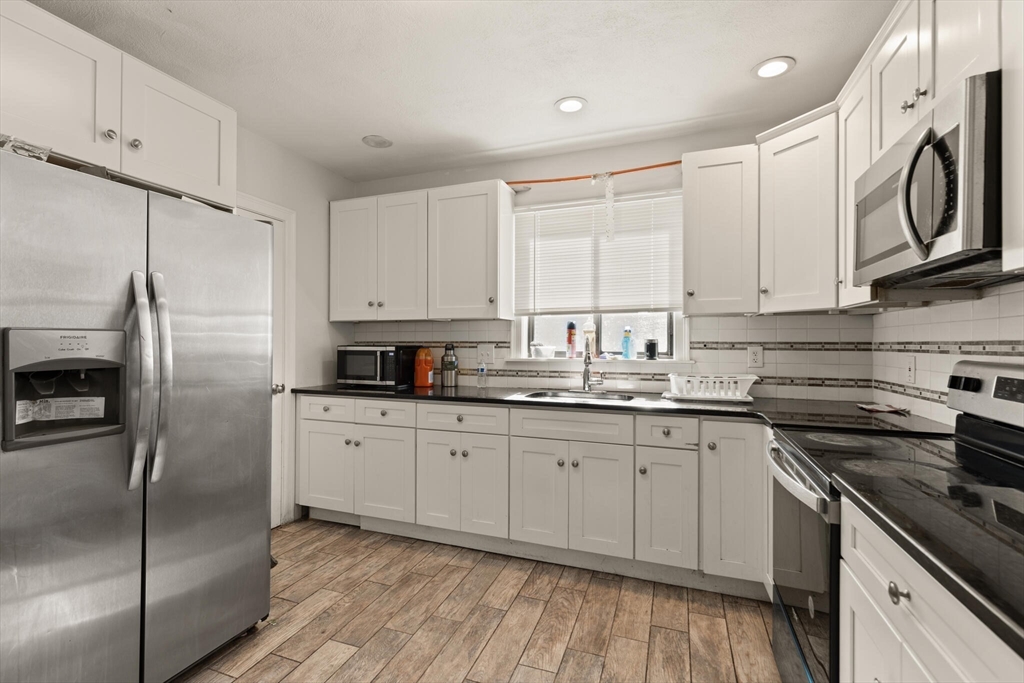 112 Johnson Street Lynn, MA 01902 - Photo 24 of 28 a kitchen with granite countertop a sink stove and refrigerator