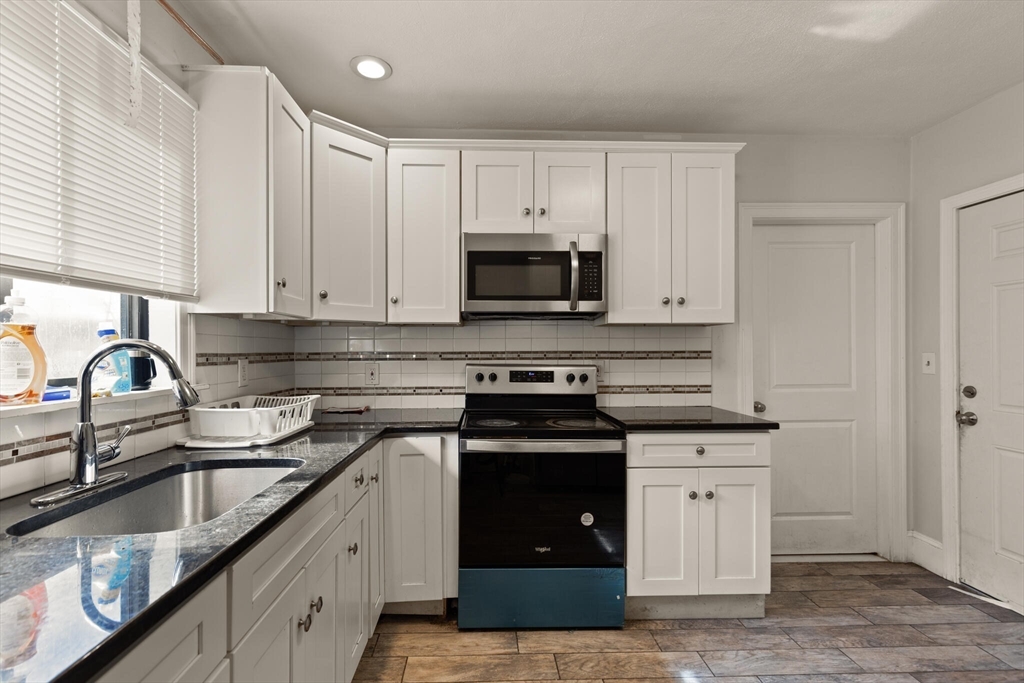 112 Johnson Street Lynn, MA 01902 - Photo 26 of 28 a kitchen with granite countertop a stove sink and cabinets