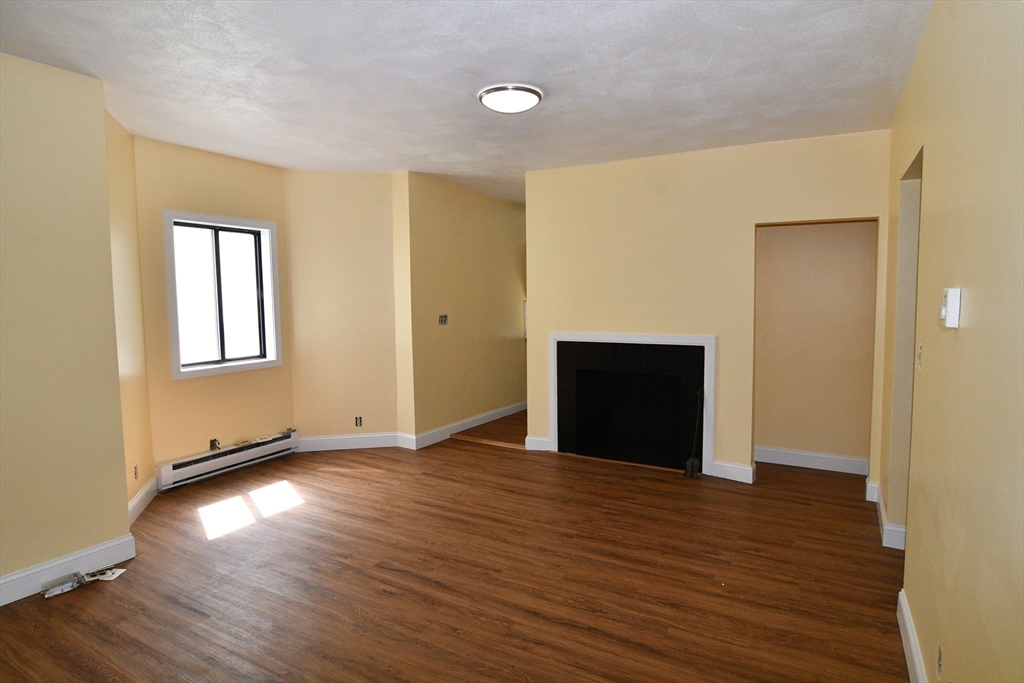 112 Johnson Street Lynn, MA 01902 - Photo 9 of 28 a view of an empty room with wooden floor and a window