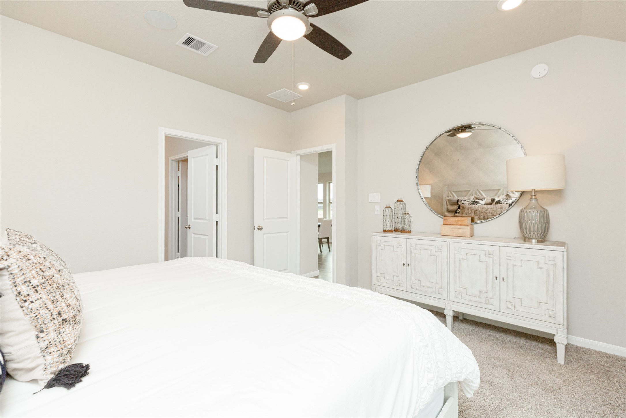 19555 Montgomery Rdg Way Montgomery, TX 77316 - Photo 17 of 21 Come decompress in the stunning primary suite after a lengthy day! Experience the luxury of plush carpeting, warm paint hues, high ceilings, and large windows featuring privacy blinds. Sample photo of completed home with similar floor plan. As-built interior colors and selections may vary.