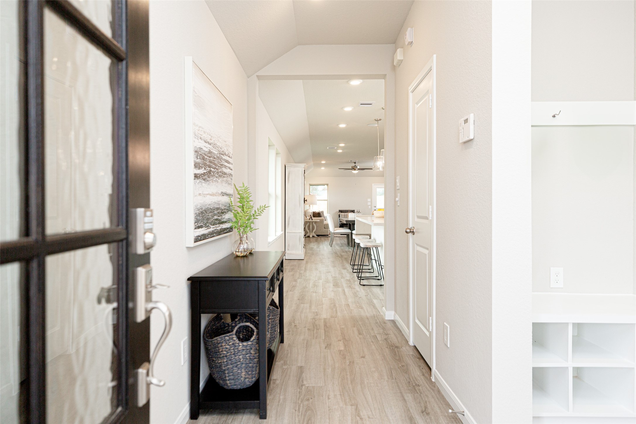 19555 Montgomery Rdg Way Montgomery, TX 77316 - Photo 8 of 21 Indulge in luxury as you step into the threshold of this breathtaking home. Greeted by a glass front door, the grand entrance beckons with its soaring ceilings, adorned with vinyl plank flooring with sleek oversized baseboards. Sample photo of completed home with similar floor plan. As-built interior colors and selections may vary.