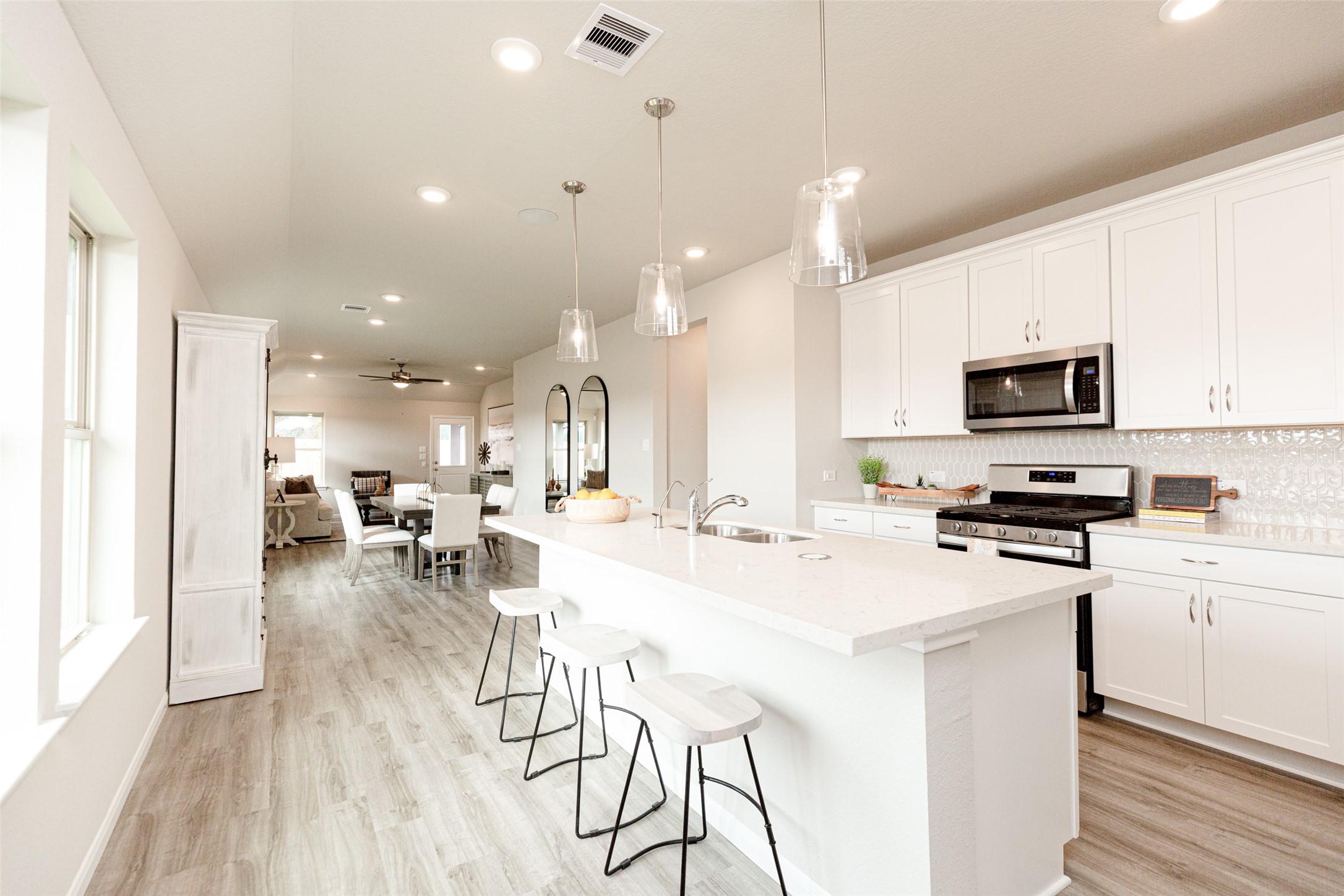 19555 Montgomery Rdg Way Montgomery, TX 77316 - Photo 10 of 21 The kitchen is a culinary haven, featuring quartz countertops, a tile backsplash, stainless steel appliances, 42” upper cabinets, and undercabinet lighting. Sample photo of completed home with similar floor plan. As-built interior colors and selections may vary.