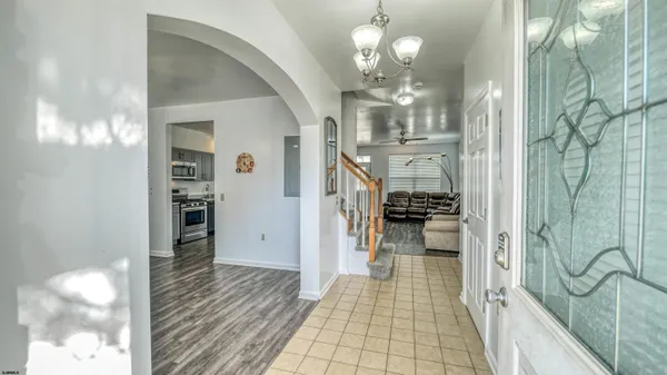 a view of a hallway with wooden floor and chandelier