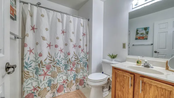 a bathroom with a granite countertop sink and a toilet